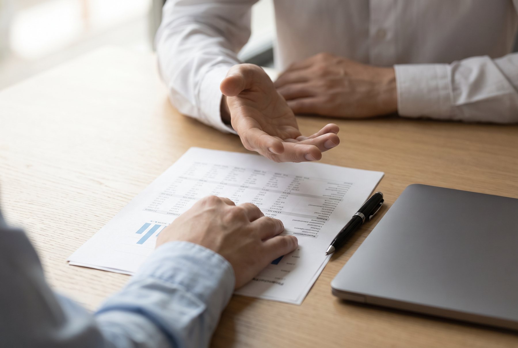 An adviser talking a client through a printed financial report
